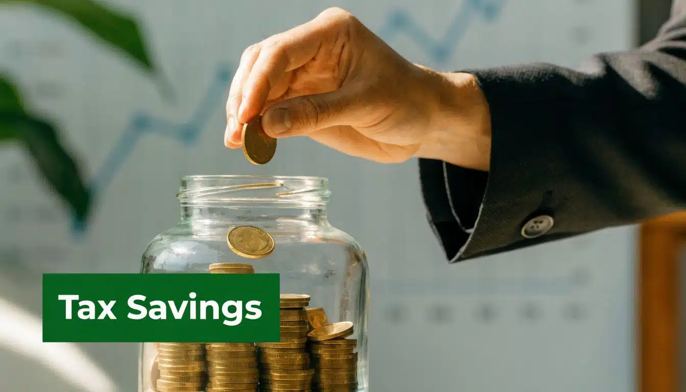 A hand placing a gold coin into a glass jar filled with coins representing financial tax savings.